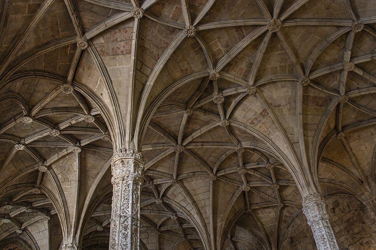 The ceiling of a building with arches and columns.