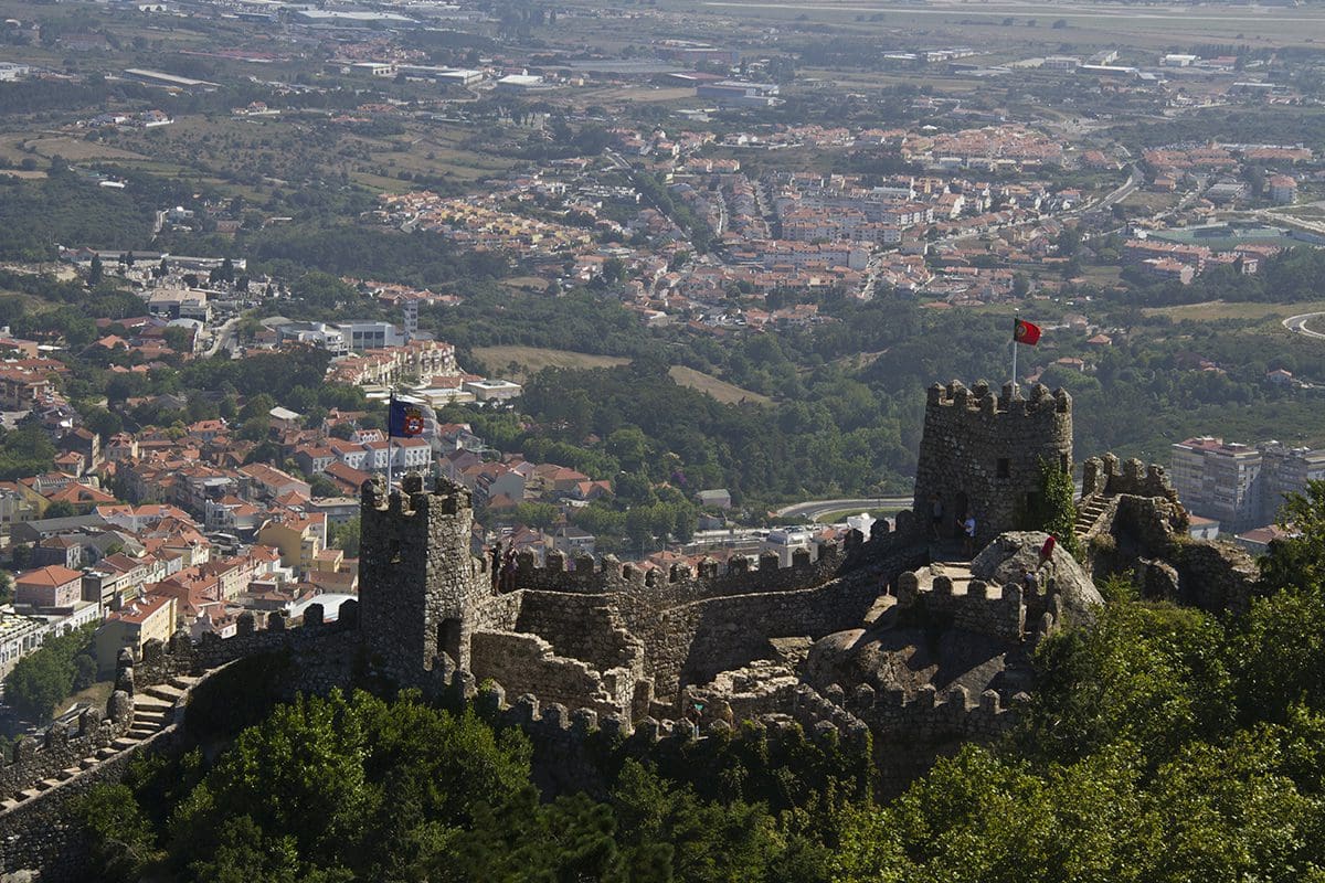 A castle on top of a hill overlooking a city.