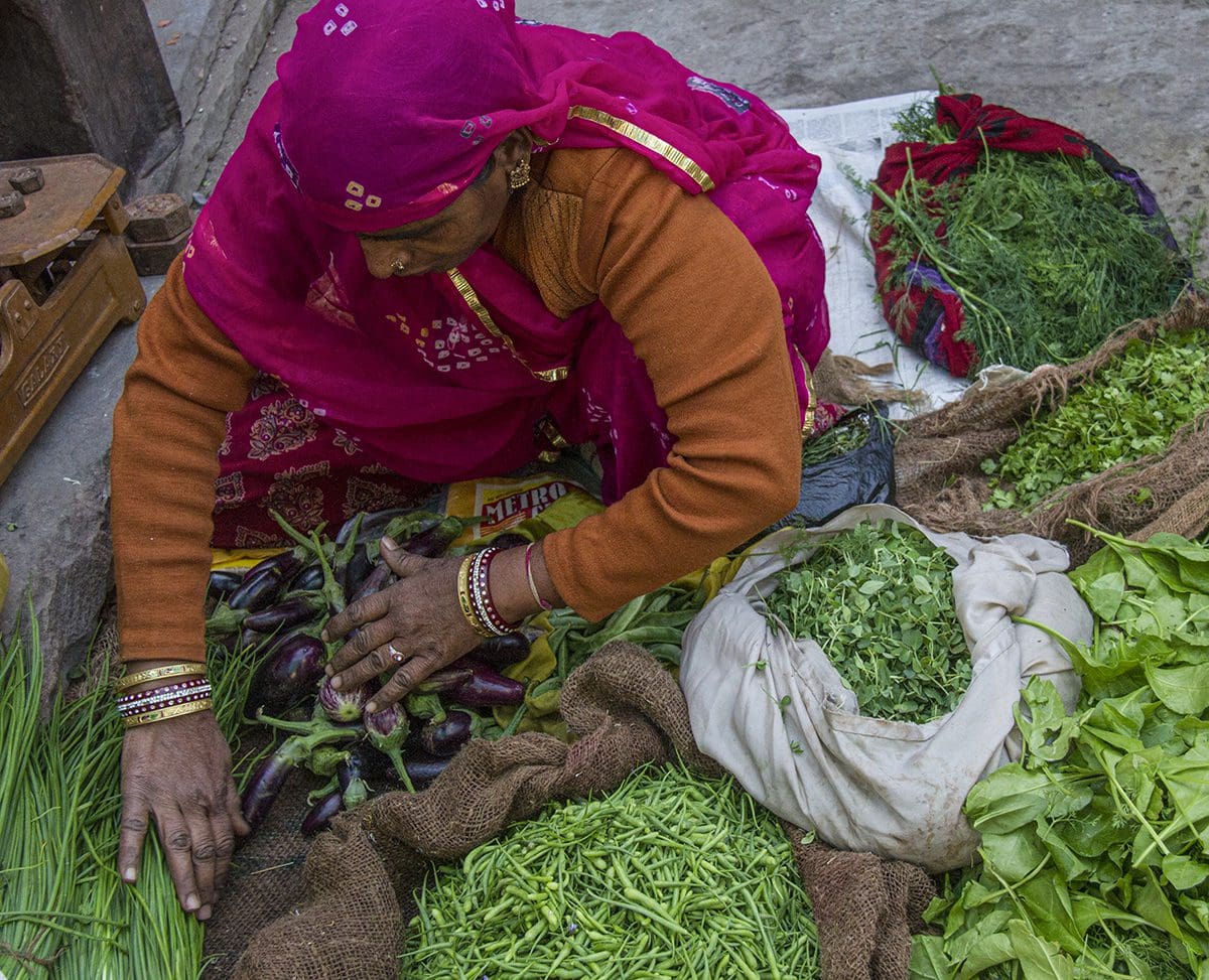 A woman is selling vegetables in a market.