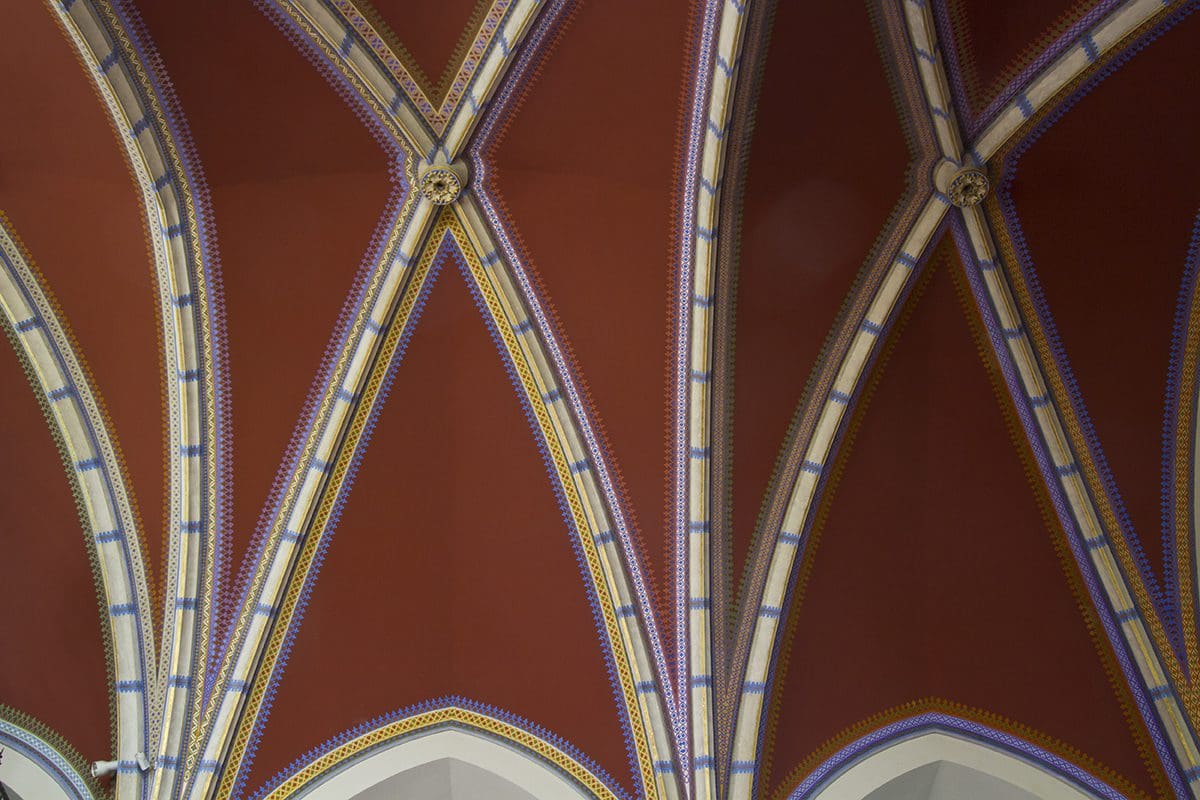 The ceiling of a church has a blue and red pattern.