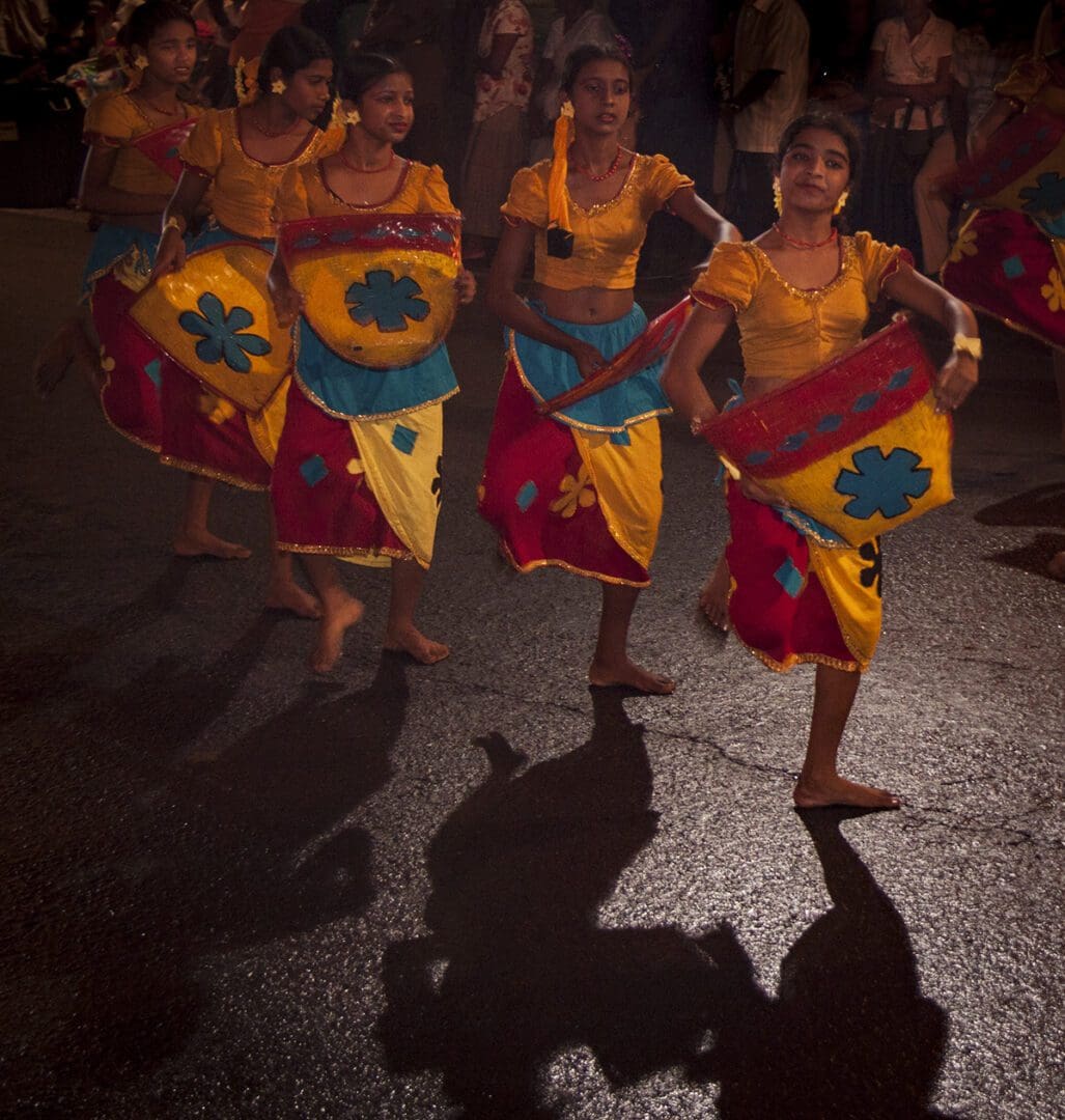 Sri lankan dancers on a street at night.