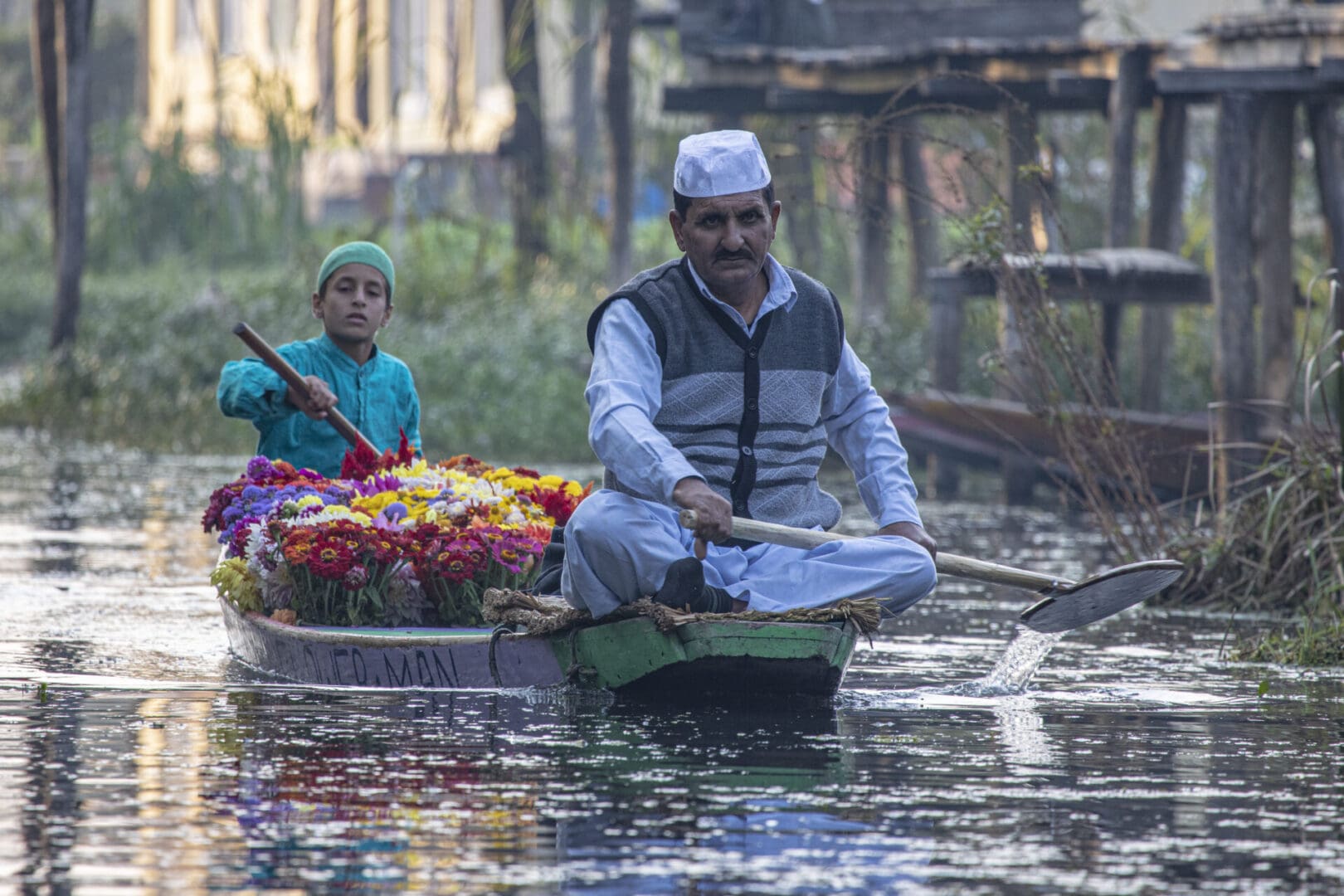 A man and a woman in a boat with flowers.
