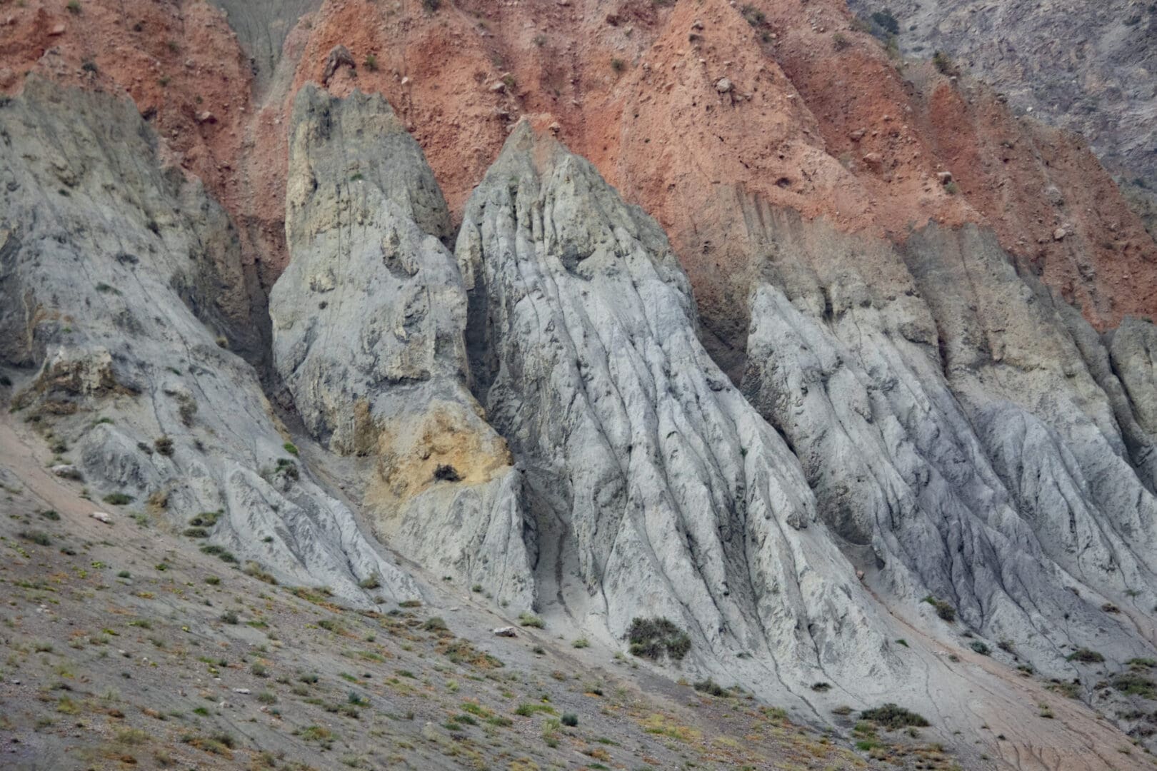 A man is riding a horse near a rocky mountain.