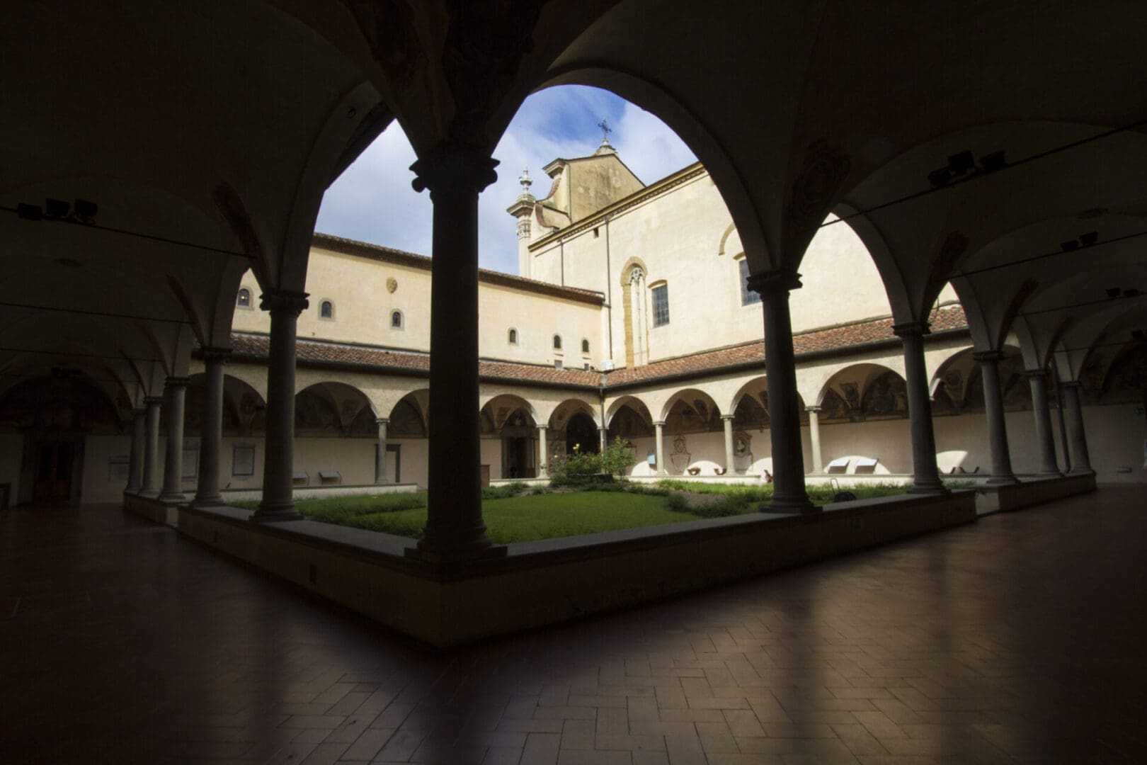 The courtyard of a large building with arches.