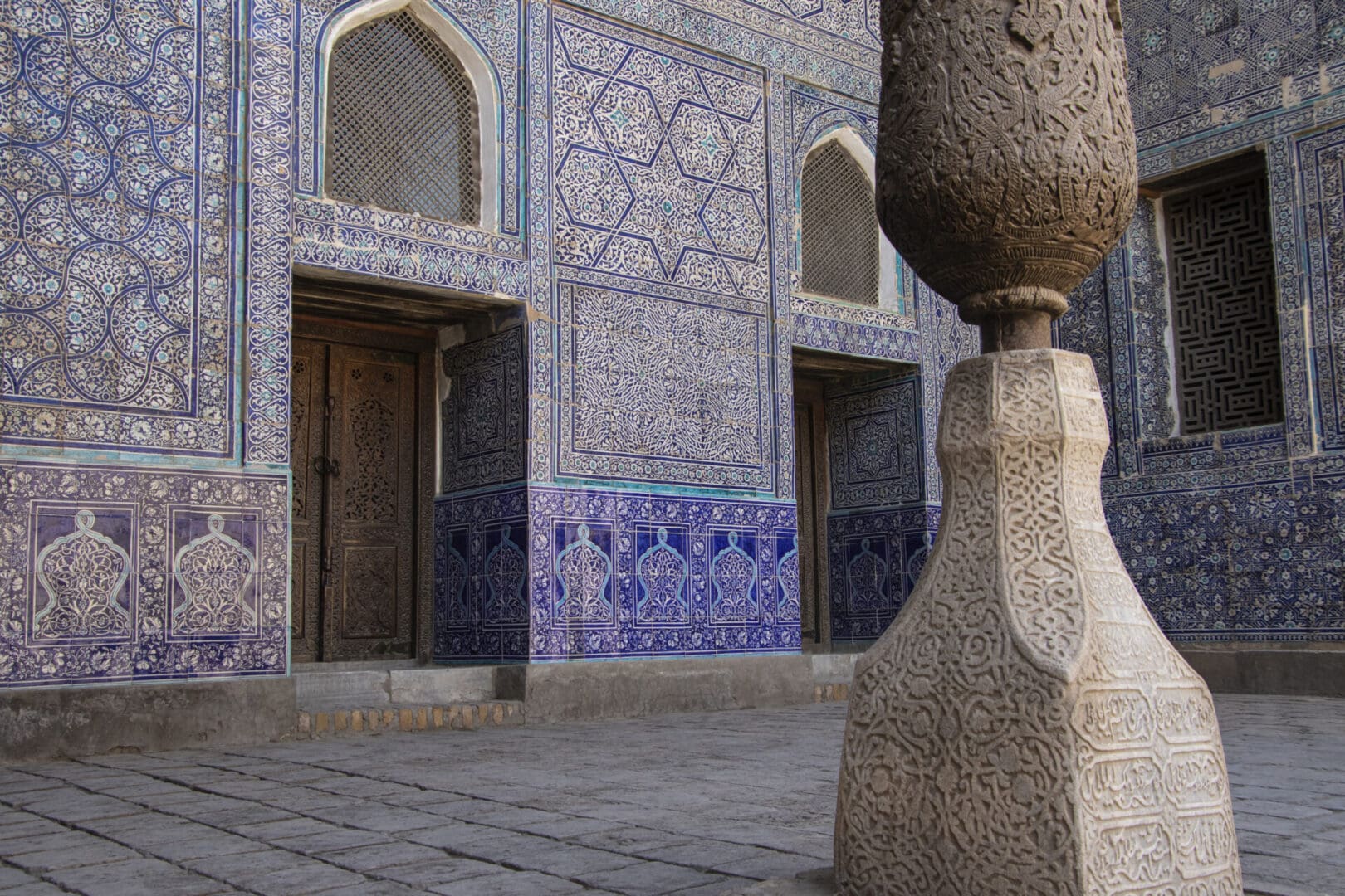 A blue tiled building with a pillar in front of it.