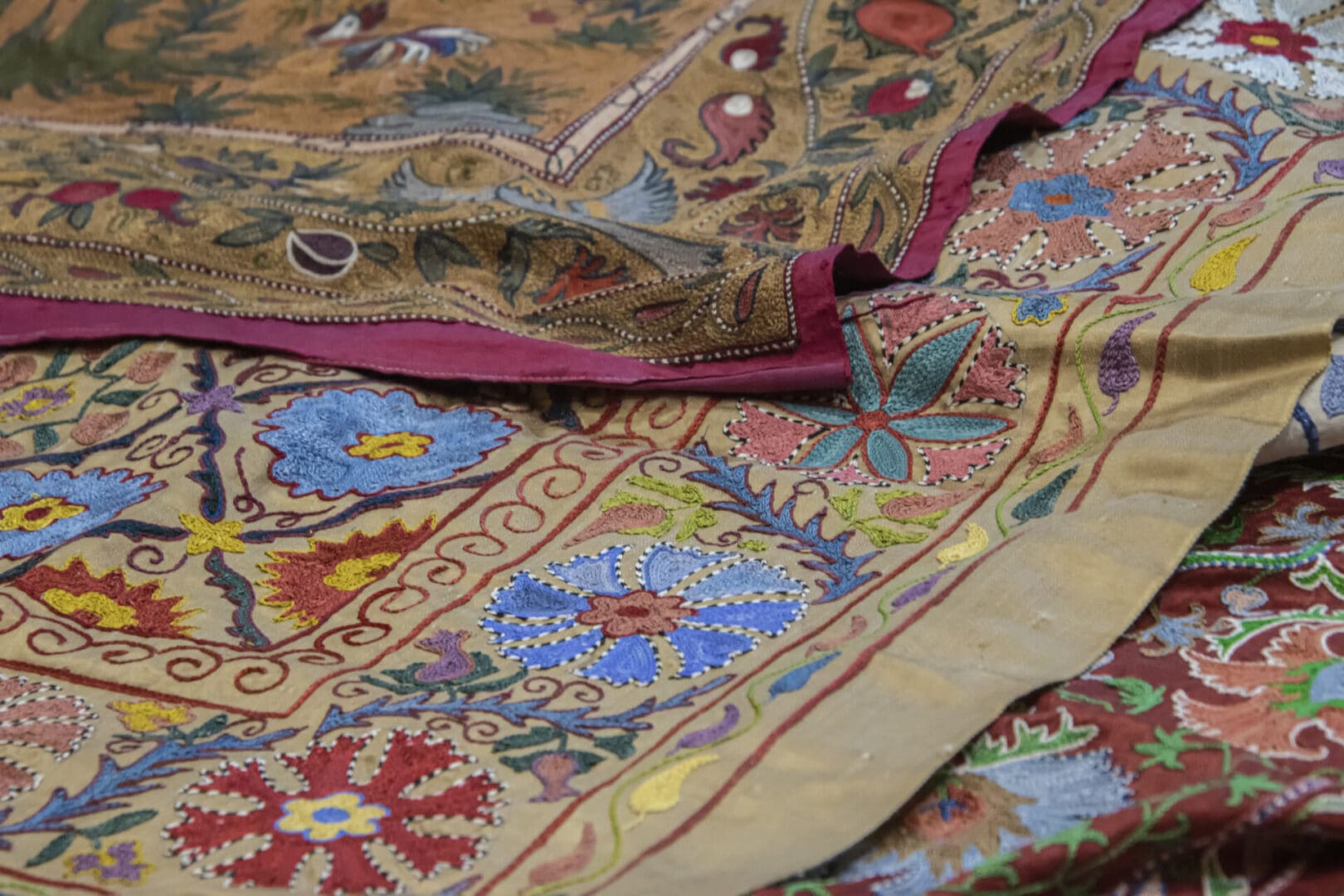 A group of colorful embroidered cloths on a table.