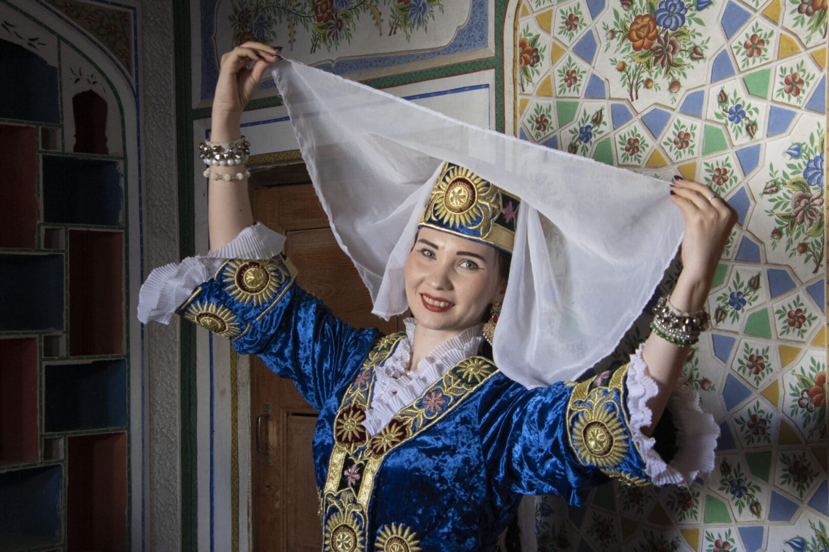 A woman in traditional uzbek costume posing for a photo.