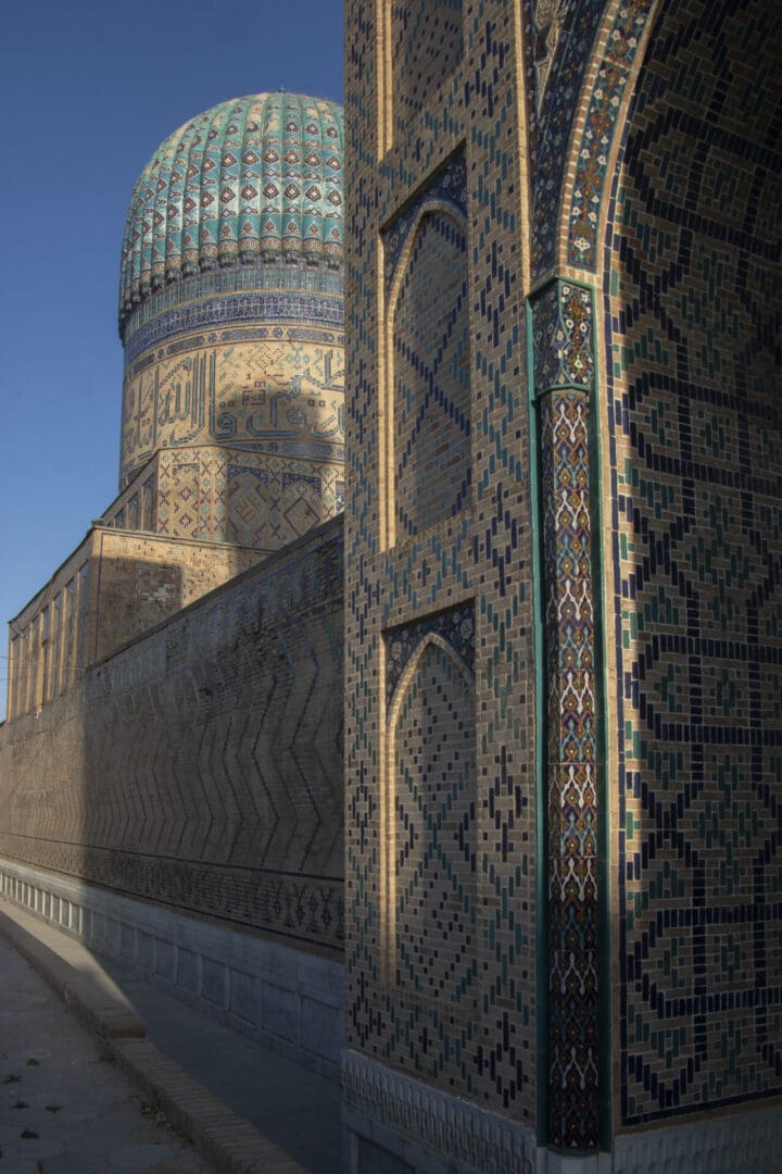 A mosque with a blue dome and tiled walls.