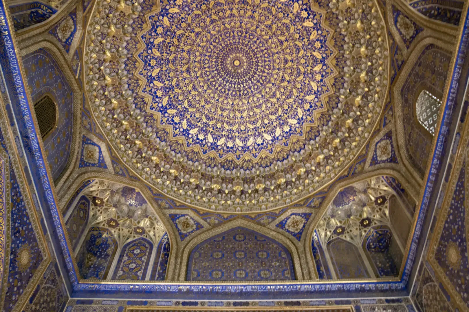 An ornate ceiling in a blue and gold building.
